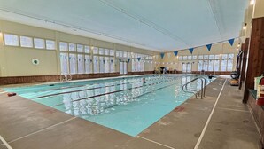 An indoor swimming pool with clear lanes, a lifeguard chair, and a windowed wall. - CubsCorner - Pool, Sauna, Gym, Close to Mountain! (Killington)