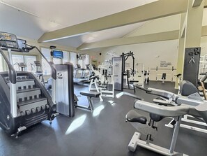 A gym with various exercise machines, a treadmill, and a weight bench. - CubsCorner - Pool, Sauna, Gym, Close to Mountain! (Killington)
