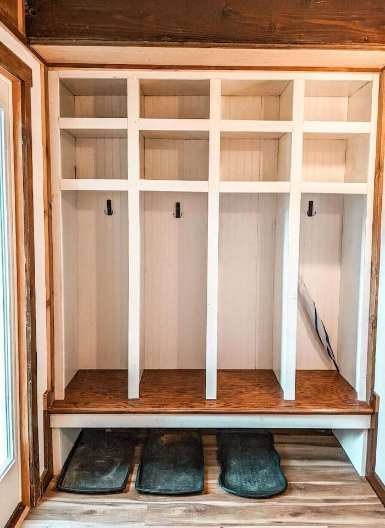 A walk-in closet with multiple shelves and a bench.