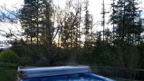 A hot tub in an outdoor setting surrounded by trees. - Large Kitchen, Hot tub, Game & Arcade Room (Hayden)