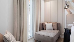 Et moderne, lyst værelse med en sofa, en lænestol og et lille bord.