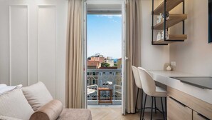 Un apartament modern amb un balcó, zona de menjador i cuina.