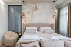 A modern bedroom with a large bed, two pendant lights, a beige armchair, and a large abstract painting on the wall. - Le Prestige Room in Split near main promenade (Split)