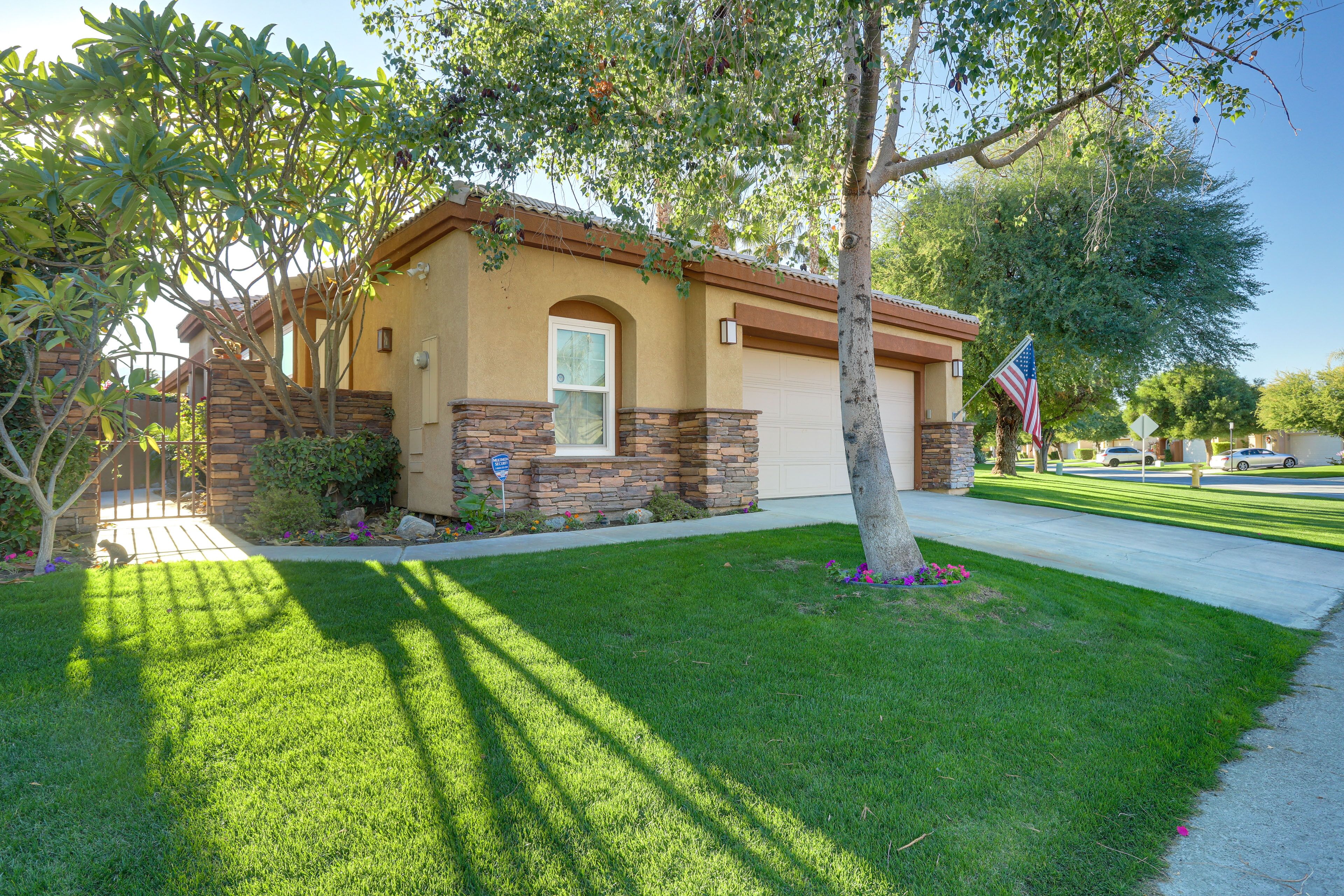 A two-story house with a stone facade, a garage, and a well-maintained lawn.