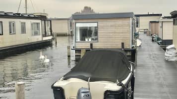 Eine Reihe von schwimmenden Häusern, ein Schwan schwimmt im Wasser.