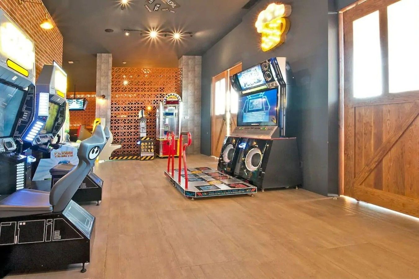 Centro de fitness com equipamentos de exercício, TV na parede e um padrão no fundo.