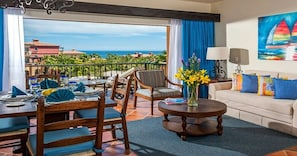 A hotel room with a balcony, dining area, and a sofa.