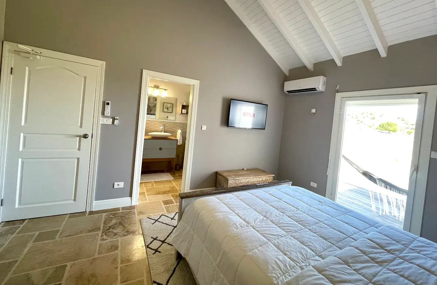 Ein Schlafzimmer mit Bett, Fernseher und Klimaanlage.