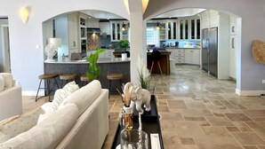 A modern kitchen with white cabinets, a central island, and stainless steel appliances.