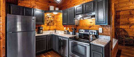 A modern kitchen with stainless steel appliances, wooden walls, and a built-in oven.