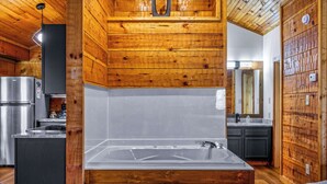 A modern kitchen with wooden walls, a stainless steel refrigerator, and a large sink. - Mountain-Modern Cabin w/BIG Jet Tub (Townsend)