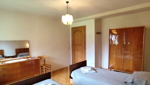 A bedroom with two beds, a wooden dresser, a chair, and a wooden wardrobe. - Breathtaking Panorama  (Cortina d'Ampezzo)