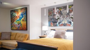 A hotel room with a large bed, a sofa, and two paintings on the walls. - Suite 14 - Sleeping Giant Hotel - Pen Y Cae Inn (Swansea Valley)