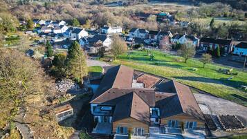 A residential area with houses, a playground, and a large building with a sloped roof.