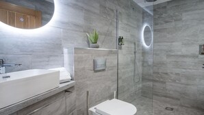 Un baño moderno con ducha, inodoro y lavamanos.