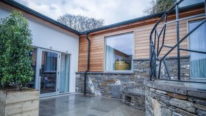 A modern house with a stone exterior, large windows, and a patio area. - Suite 4 - Sleeping Giant Hotel - Pen Y Cae Inn (Swansea Valley)
