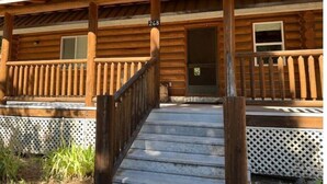 Une cabane en bois dotée d’une véranda, d’un escalier et d’une porte portant le numéro 248.