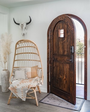 Cozy retreat with a rustic door, woven chair, and unique decorative touches.