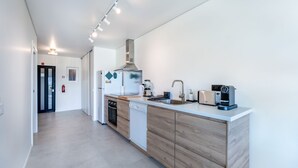 Eine moderne Küche mit einer zentralen Kochinsel, eingebauten Geräten und einem klaren, minimalistischen Design.