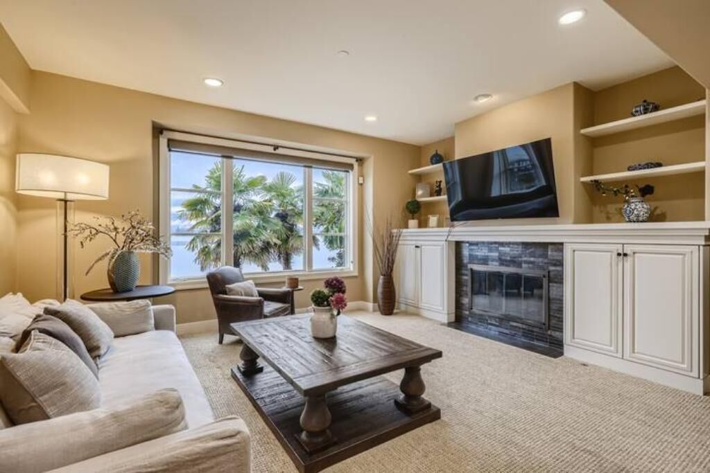 A living room with a sofa, coffee table, and a fireplace.