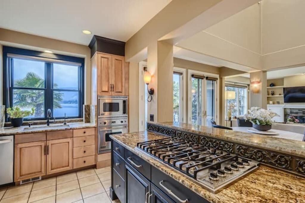 A spacious kitchen with a large island, built-in appliances, and a view of the outdoors.