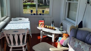 Une pièce chaleureuse avec une table blanche, un banc rembourré et un canapé.