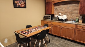 A compact kitchen with wooden cabinets, a microwave, a toaster, and a sink. - SPACIOUS AND QUIET (Meriden)