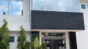 A hotel named "La Casa No 3" with a modern facade, large windows, and potted plants in front. - HOTEL LA CASA 3 (Montería)