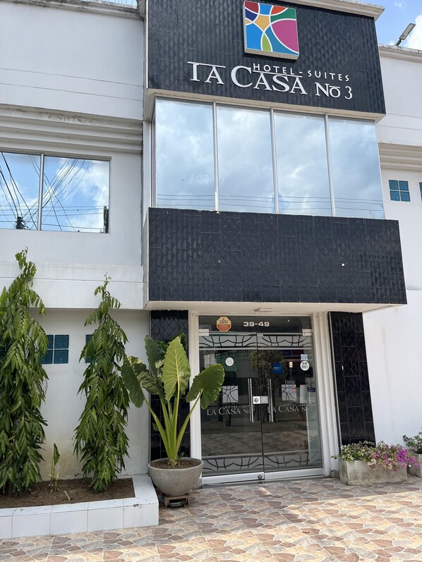 A hotel named "La Casa No 3" with a modern facade, large windows, and potted plants in front. - HOTEL LA CASA 3 (Montería)