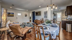 A dining area with a round table, leather chairs, and a chandelier. - Artist Cottage - Walk to Great Shops and Restaurants  (Oklahoma City)