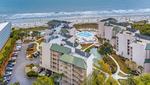 Een resort met zwembad, toegang tot het strand en een parkeerplaats.