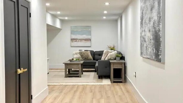 A modern living room with a sofa, coffee table, and side tables. - Modern, Bright, Spacious 2 Bedroom Guest Suite - Entire Separate Basement  (Grimsby)