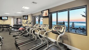 Un gimnasio con cintas de correr, mancuernas y equipamiento de ejercicio.