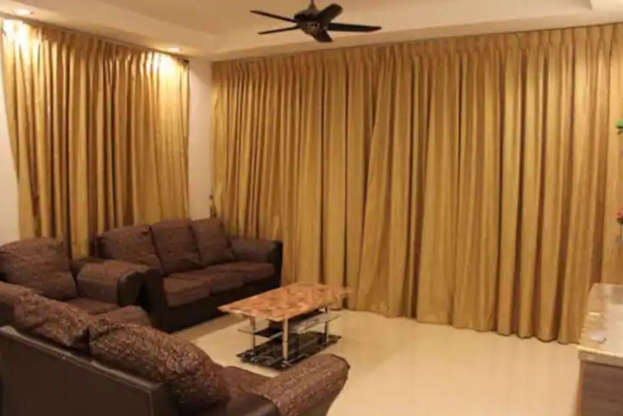 A living room with a brown sofa set, a coffee table, and a ceiling fan.