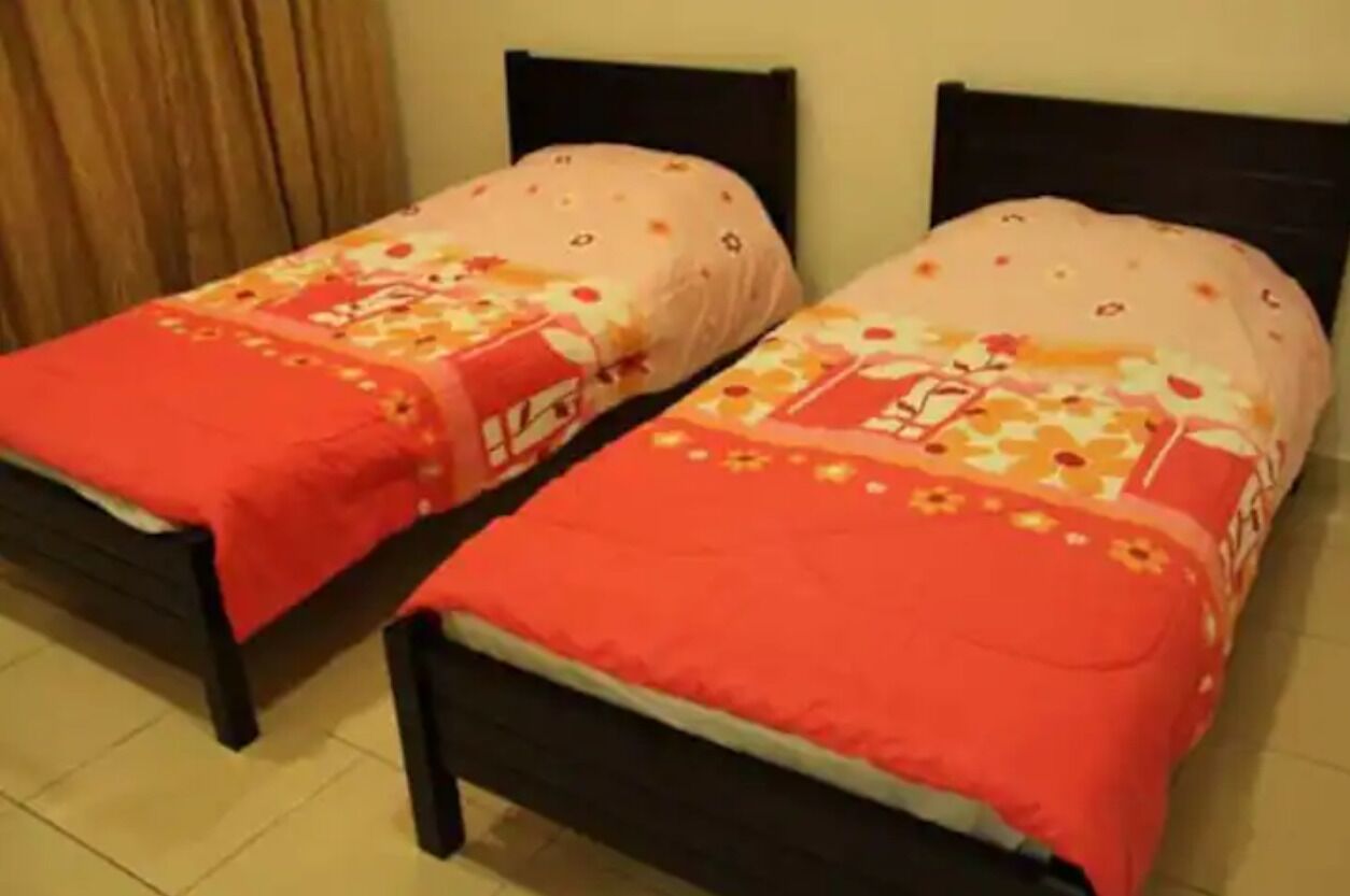 Due letti singoli con montature in legno scuro e biancheria da letto a motivi floreali.