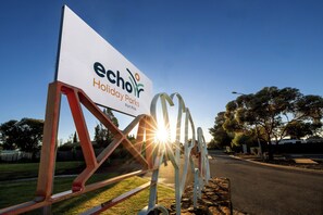 A sign for Echo Holiday Parks with a clear sky and sunlight in the background. - Echo Holiday Parks - Port Pirie (Solomontown)