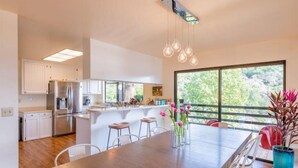 A modern kitchen with white cabinets, stainless steel appliances, and a large island with bar stools. - Verona: Awesome Views, Pool, Vineyard, Hot Tub! (Ukiah)