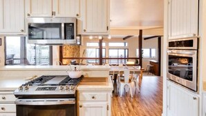 A kitchen with white cabinets, a microwave, a gas stove, and an oven. - Verona: Awesome Views, Pool, Vineyard, Hot Tub! (Ukiah)