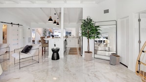 A spacious living area with a marble floor, a large mirror, a potted plant, and a seating area with a sofa and chairs. - Lux FL Waterfront Heaven, Pool, Jacuzzi, World Cup? Stadium is Only 15 Mins Away (Fort Lauderdale)