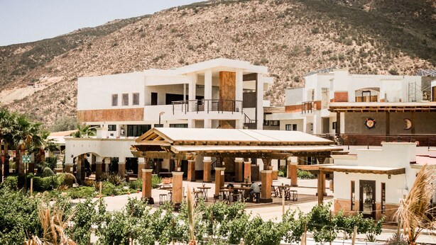A hotel with a courtyard, outdoor seating, and a mountainous backdrop. - Limbo Hotel Boutique (Valle de Guadalupe)