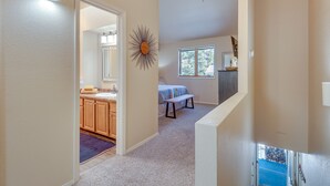 A hallway leading to a bedroom with a window, a sunburst decoration on the wall, and a ceiling fan. - Cloudcroft Vacation Rental ~ 4 Mi to Skiing! (Cloudcroft)