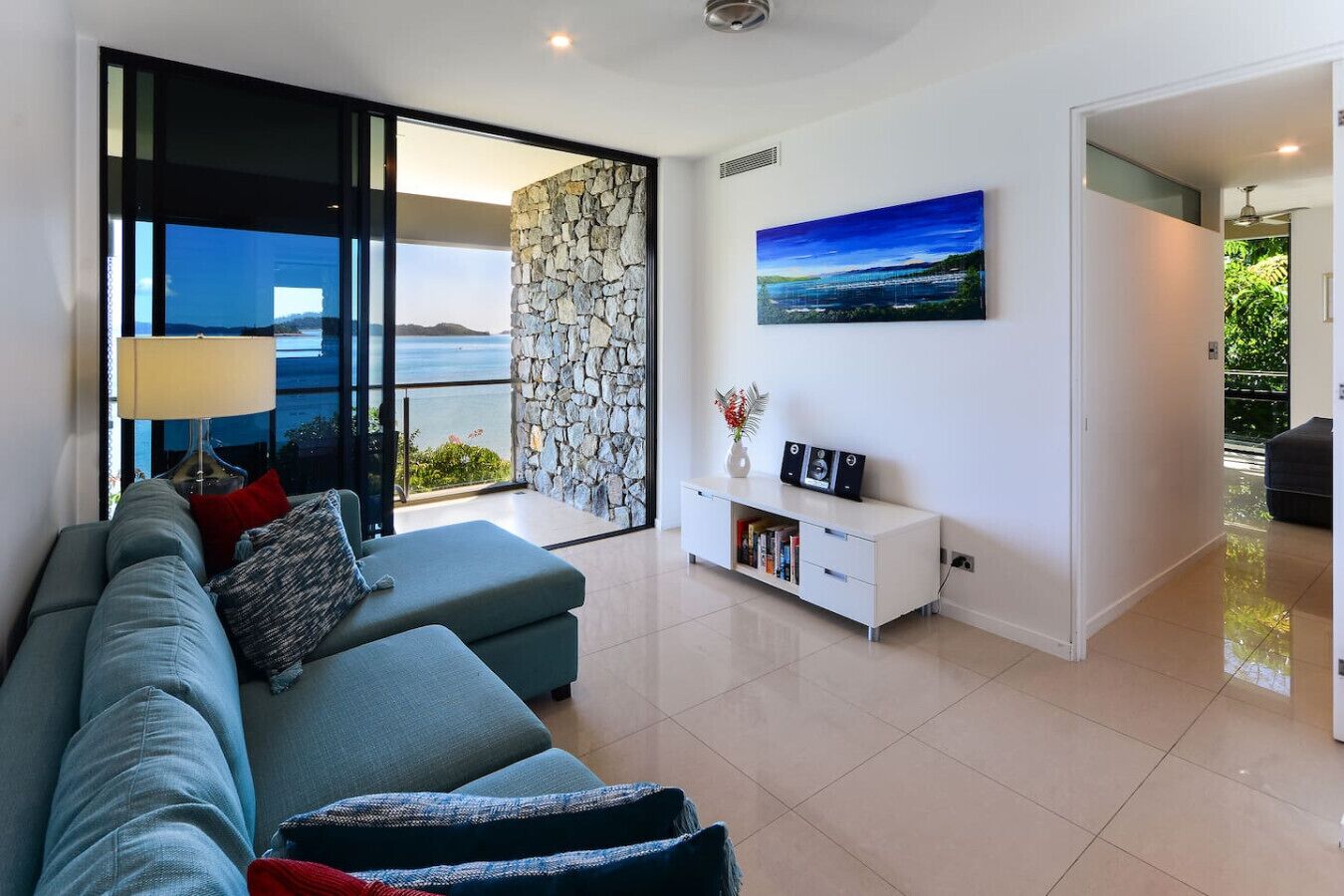 A modern living room with a sofa, a white console table, and a painting.
