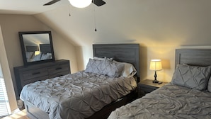 A bedroom with two beds, a nightstand with a lamp, a dresser, and a ceiling fan. - Spacious 3 Bedroom Home in Ewing, NJ – Modern Comfort in a Prime Location (Trenton)