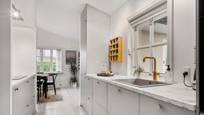 Eine moderne Küche mit einem großen Fenster, einer eingebauten Spüle und einem Holzboden.