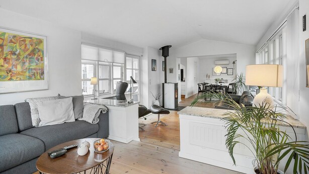 Ein modernes Wohnzimmer mit Sofa, Couchtisch und Kamin.