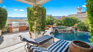 An outdoor patio with a pool, lounge chairs, and a grill area. - La Quinta Resort-Style Retreat (La Quinta)