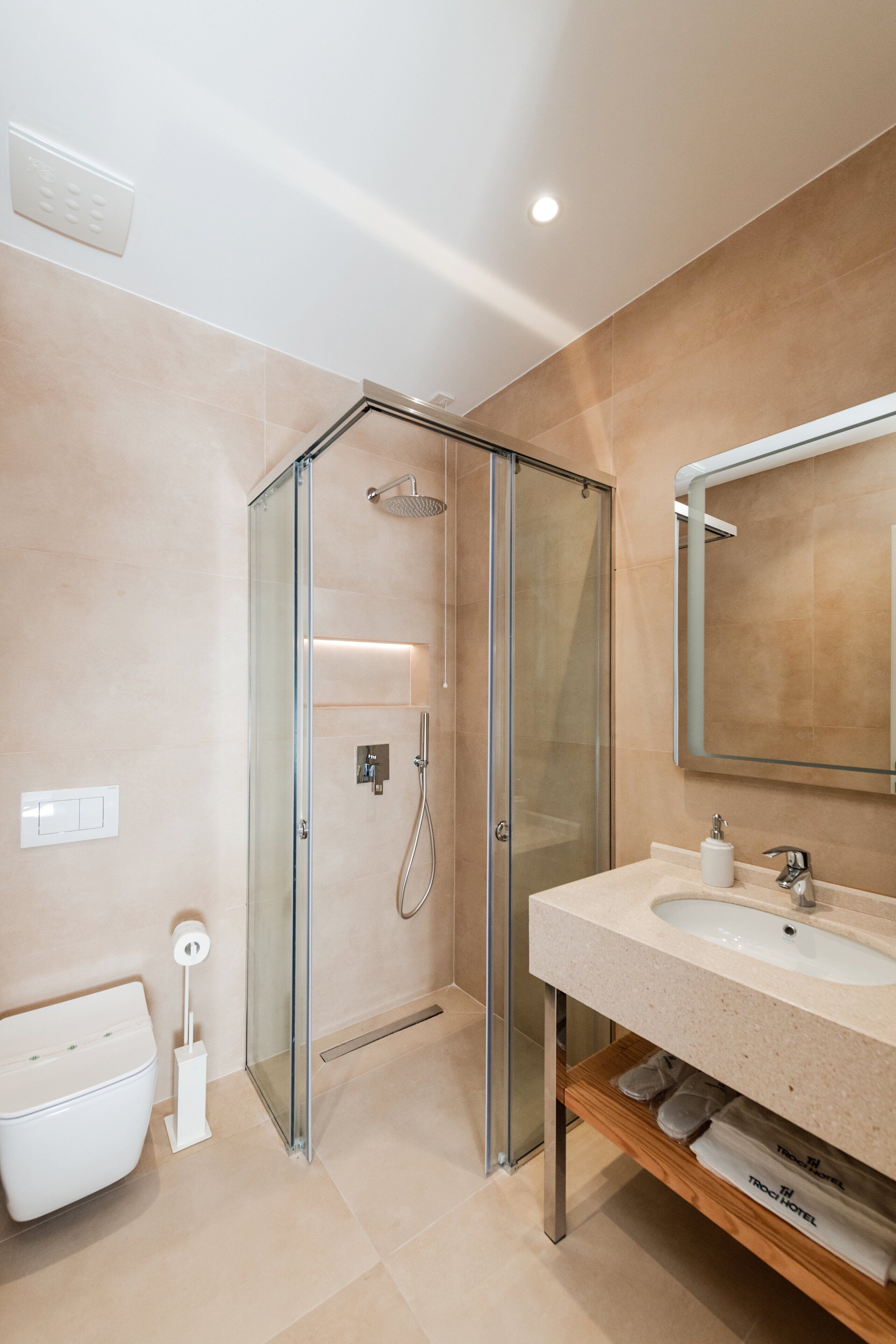 Un bagno moderno con cabina doccia in vetro, lavabo con specchio e servizi igienici.