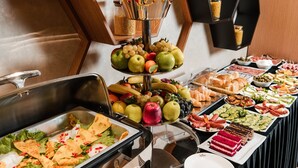 Un bufé con diversos alimentos, incluyendo frutas, verduras y postres.