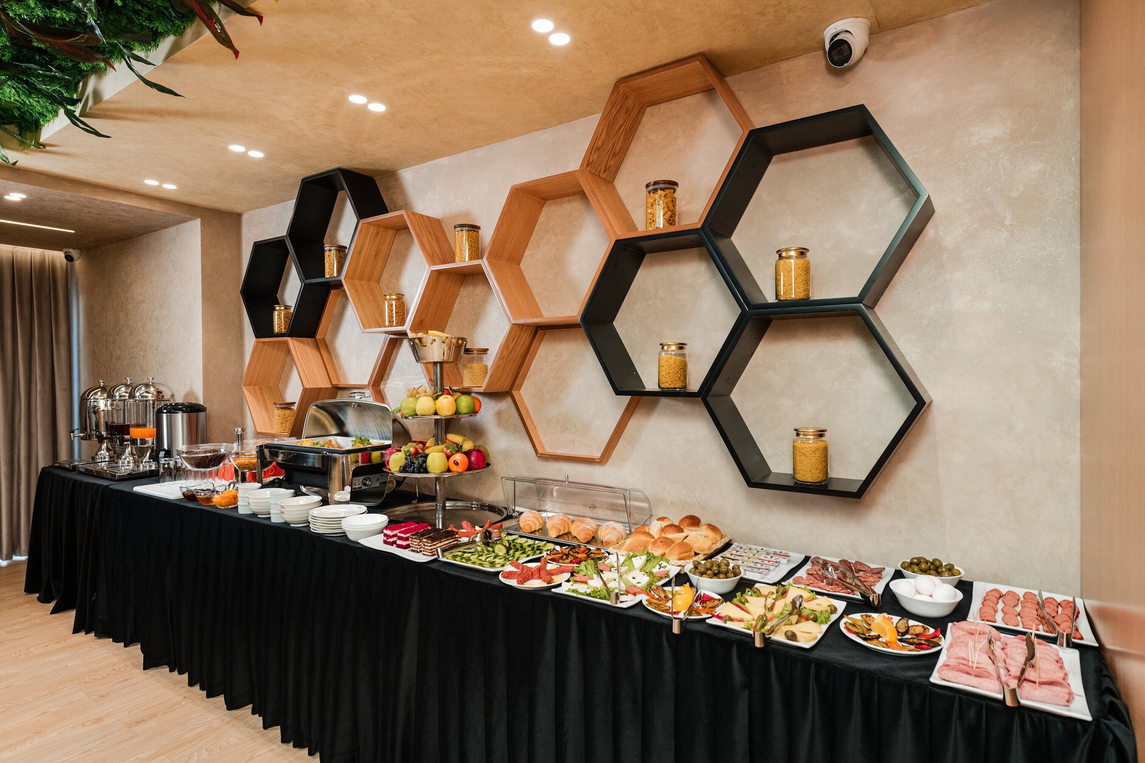 Buffet amb diferents aliments, incloent fruita, verdura i carns, presentats sobre una taula amb estovell negre.