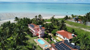 A coastal property with a swimming pool, solar panels, and a beach view. - Xaréu Flats Maragogi (Maragogi)
